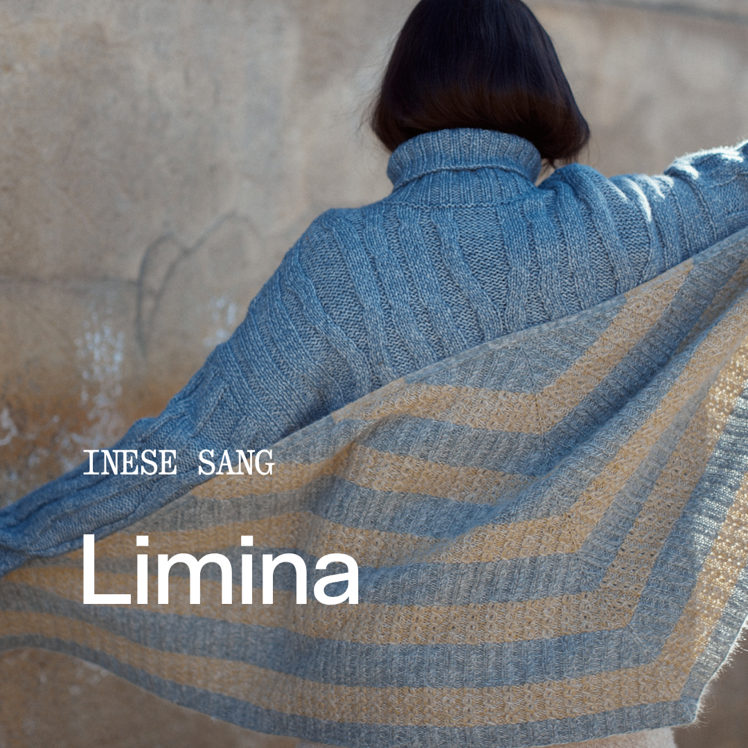 A woman seen from behind wearing a blue ribbed turtleneck sweater and a beige-and-blue striped knit shawl draped over her shoulders, standing against a textured stone wall. White text overlays read 'INESE SANG', 'Limina', and 'LAINE'.