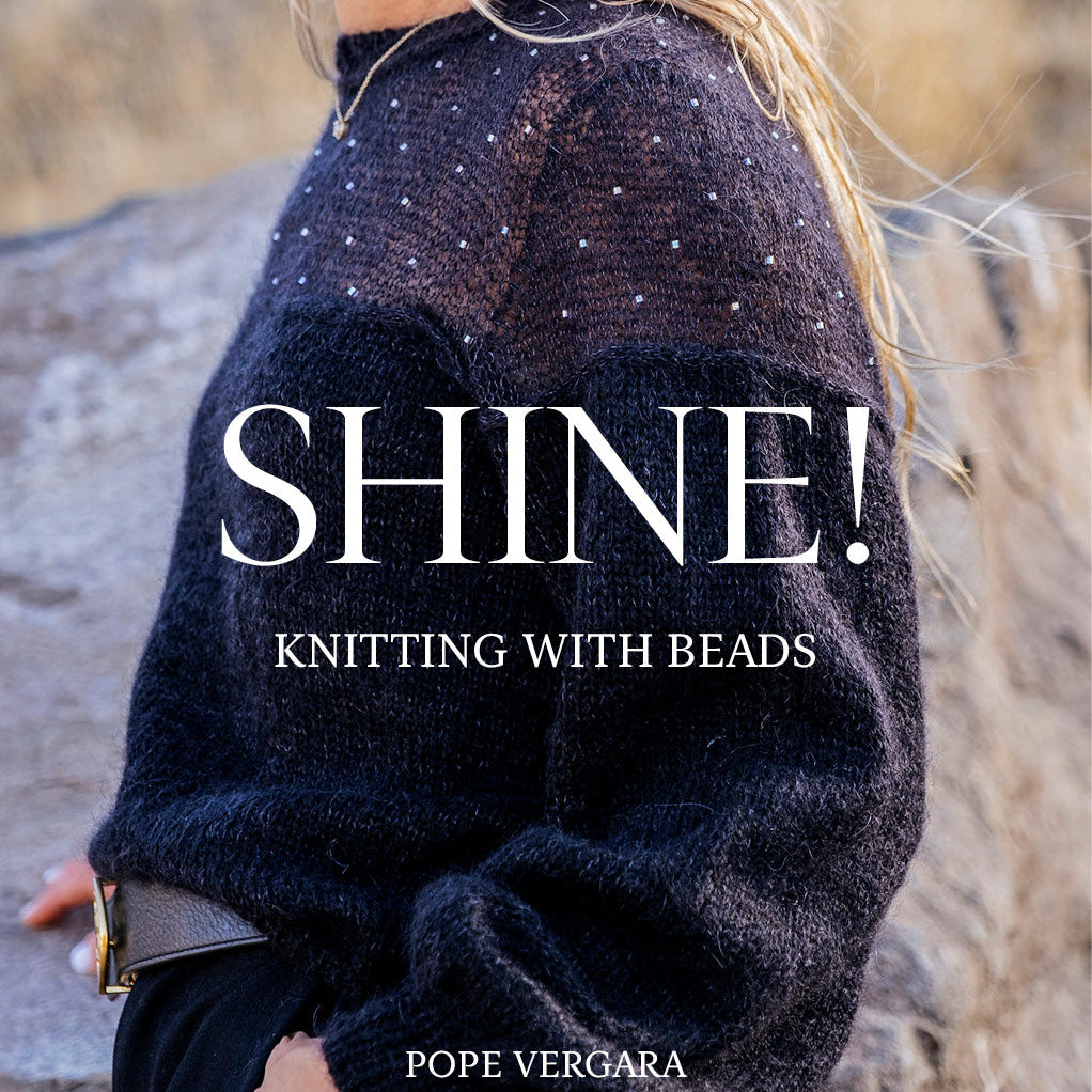 A woman wearing a dark fuzzy knit sweater with small bead details, photographed outdoors against a blurred rocky background. Large overlaid text reads “SHINE! KNITTING WITH BEADS” and the author name “POPE VERGARA” appears at the bottom.