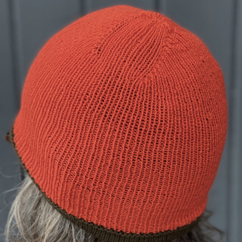 Photo of a person wearing a bright orange hat shown from behind
